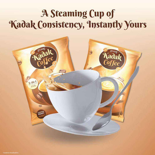 Kadak 3-in-1 coffee premix packets with a steaming cup of coffee and a spoon on a saucer